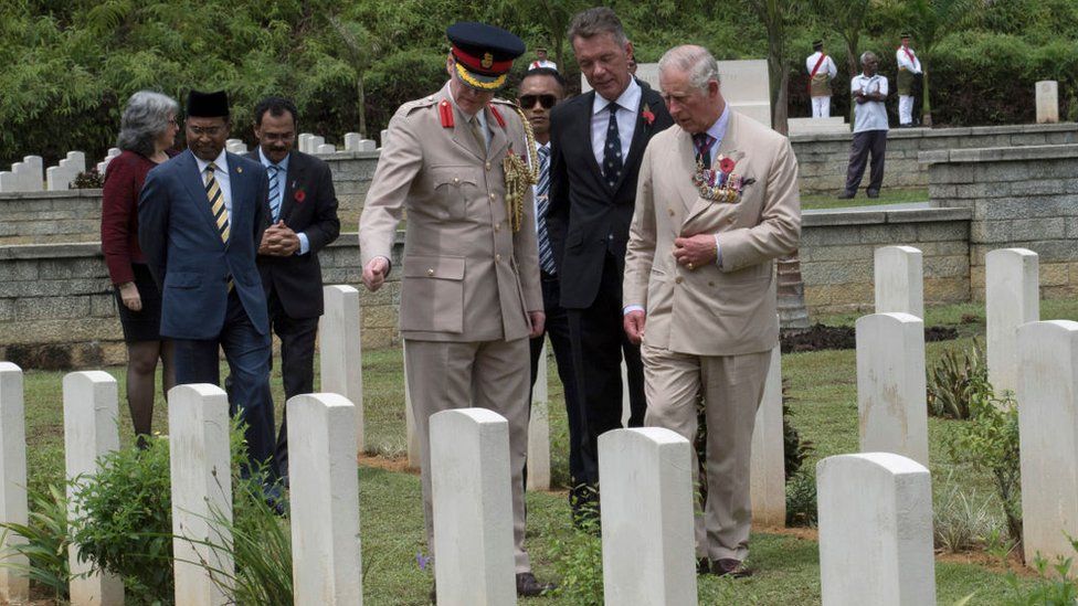 Prince Charles is shown the gravestone of Squadron Leader A S K Scarf .VC. during a visit to the Taiping Commonwealth War Graves Cemetery on 4 November 2017 in Taiping Malaysia