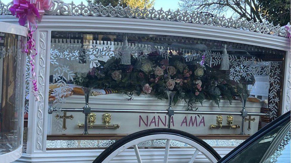 Elianne Andam's coffin in a white coach pulled by white horses