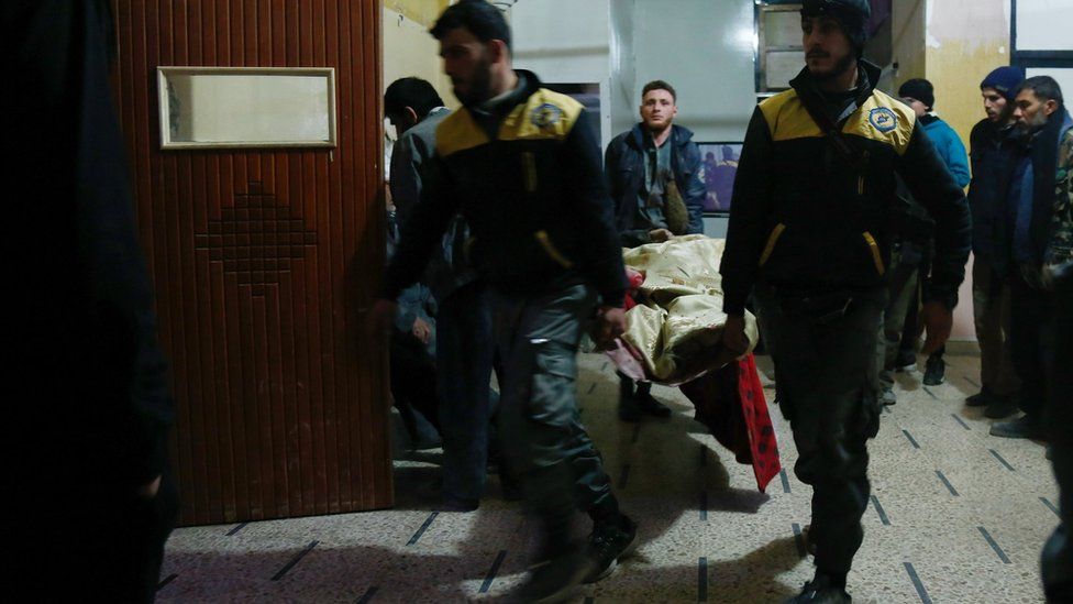Syrian paramedics carry a victim into a make-shift hospital in the besieged rebel-held town of Douma, on January 3, 2018