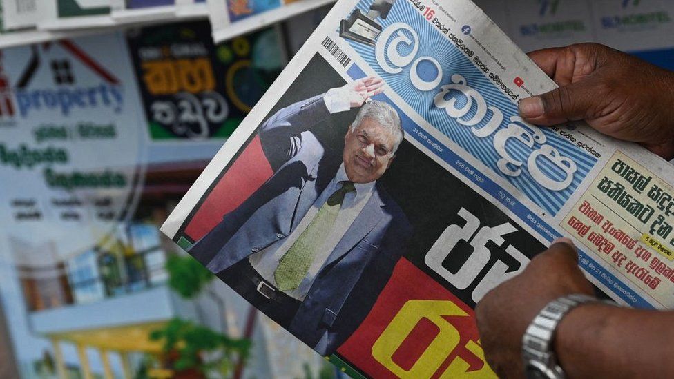 A man buys a newspaper with front page news of Sri Lanka's president-elect Ranil Wikeramasinghe at a newsstand in Colombo on July 21, 2022