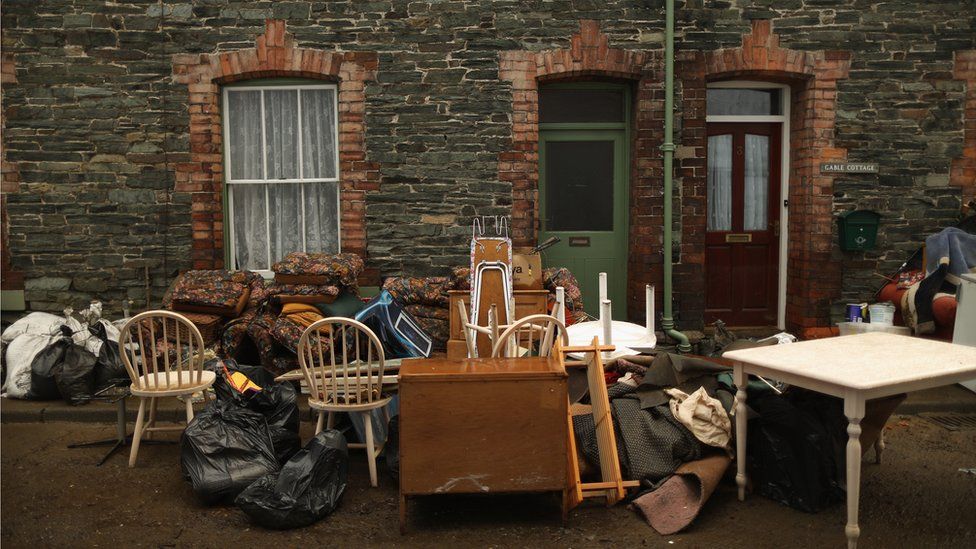 Water damaged possessions sit outside a flooded home in Keswick