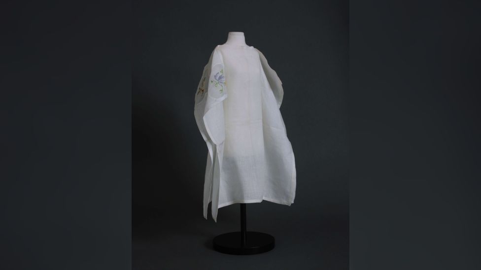 A miniature mannequin wearing a white cape