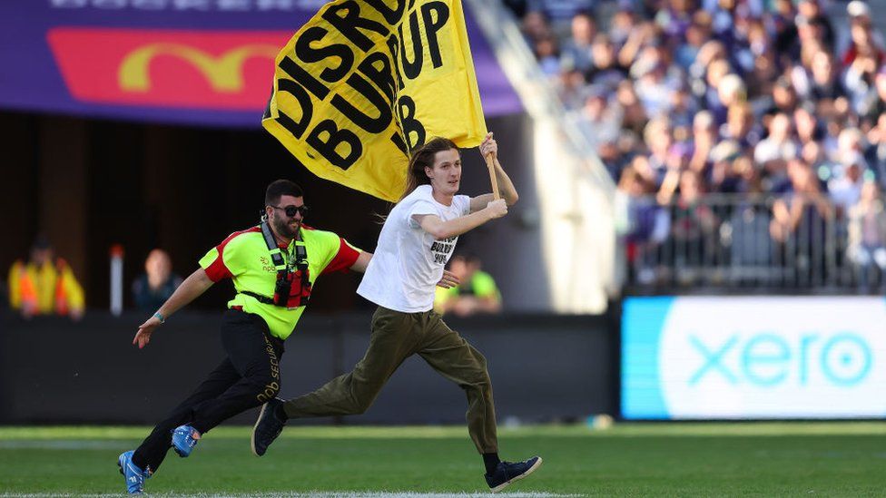 A climate campaigner storms the pitch at an Australian Football Rules match in Perth