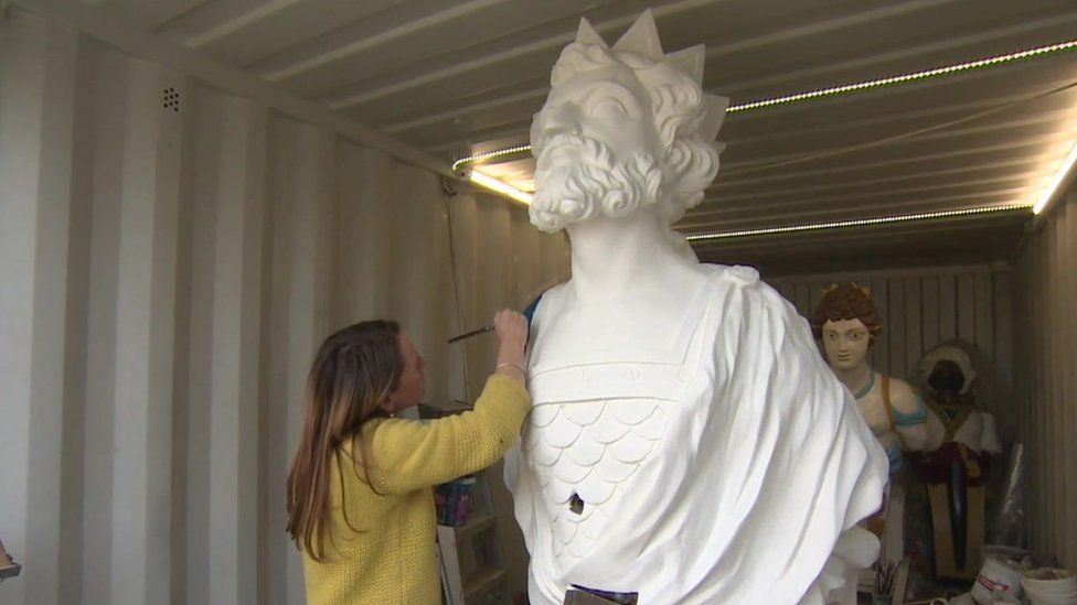 Painter Sarah Brown working on a figurehead