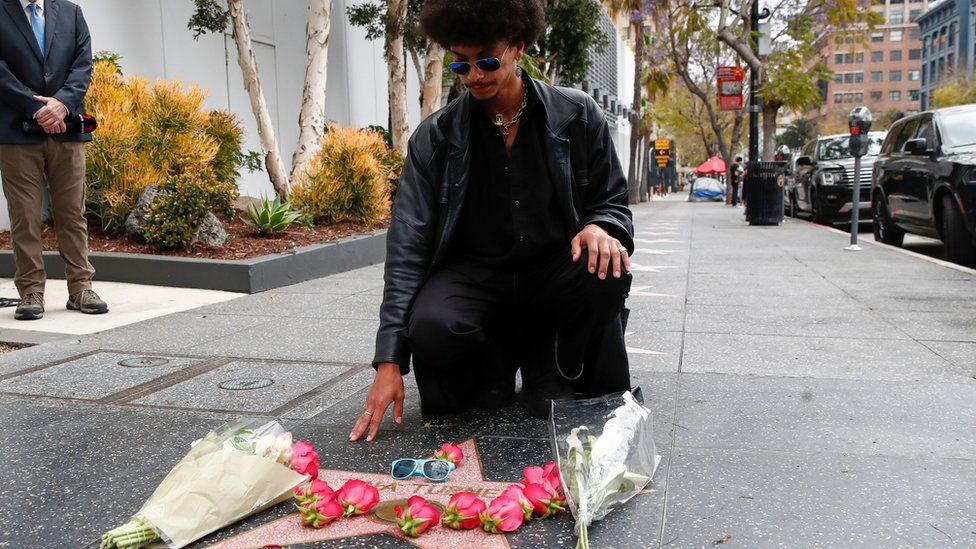 A man leaves flowers on Tina Turner's star on the Hollywood Walk of Fame