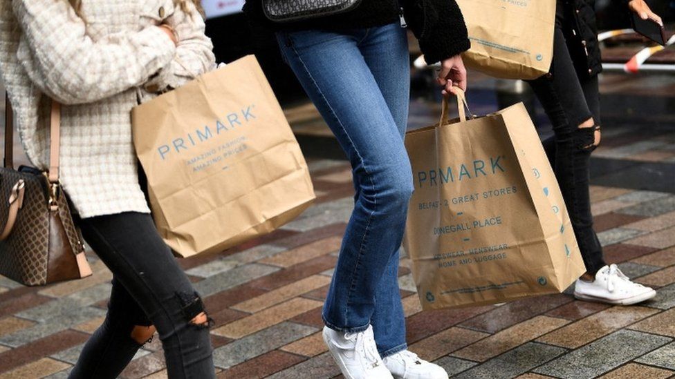 Люди несут сумки с покупками Primark