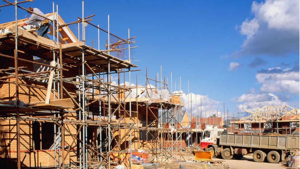 Construction site, workers building houses - stock photo