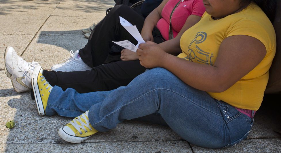 A woman with obesity sits on the pavement in Mexico City on May 20, 2013