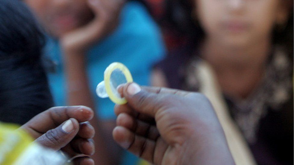 A volunteer at Nagarsoga village demonstrates use of a condom during a training programme on safe sex practices and HIV/AIDS in Latur in Maharashtra in 2008