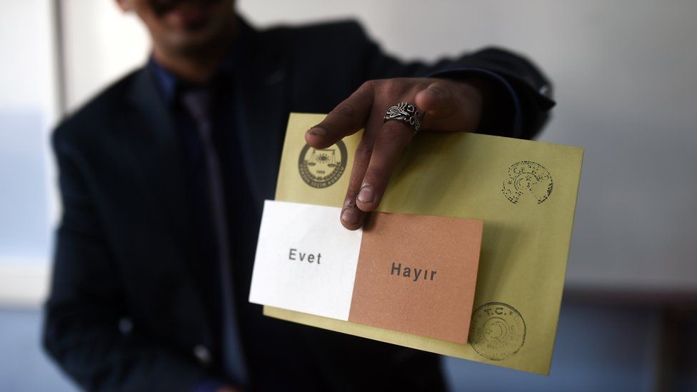 A man shows a voting ballot with the words in Turkish that read, 'Evet' or Yes and 'Hayir' or No as people vote in the referendum on expanding the powers of the Turkish president on April 16, 2017 in Istanbul.