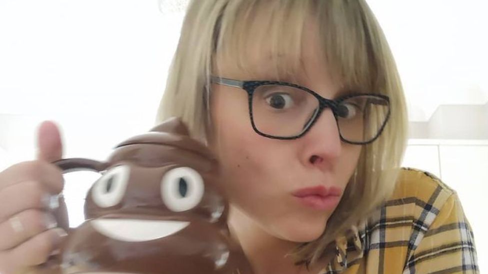 Rachel holding a poo emoji mug