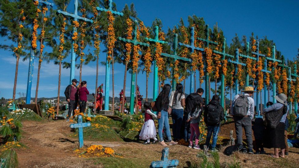 Коренные жители цотзиле украшают могилы родственников в Сан-Хуан-Чамула, штат Чьяпас
