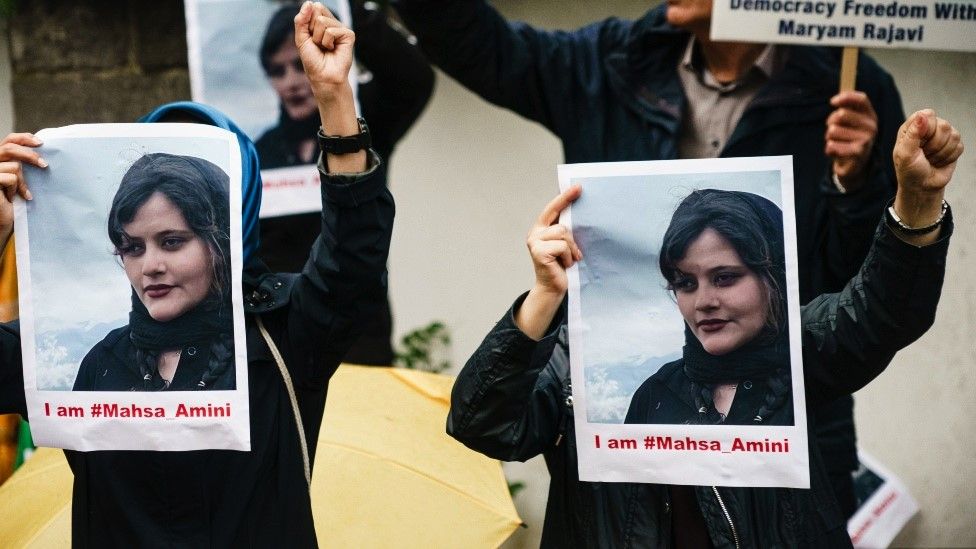 Protesters hold up picutres of Mahsa Amnini in Berlin, Germany