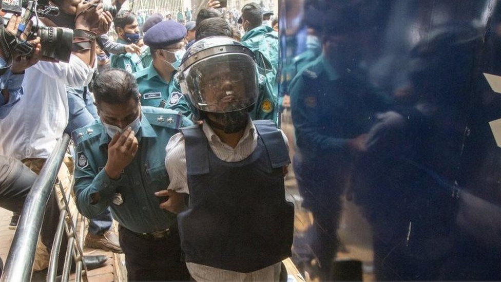 Wearing a helmet and a ballistic vest, one of the accused murderers (R) of blogger-writer Avijit Roy is escorted to the court in Dhaka, Bangladesh, 16 February 2021.