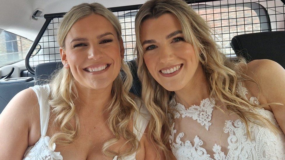 Two brides in the back of a police car