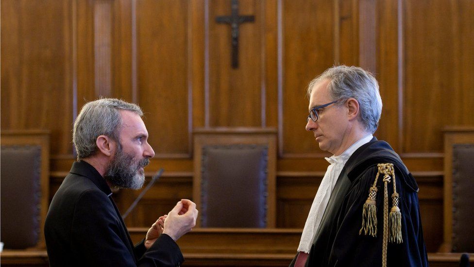 Father Carlo Alberto Capella, a Catholic priest sentenced to five years in jail for possessing child pornography, talks with his lawyer during a trial at the Vatican (June 23, 2018)