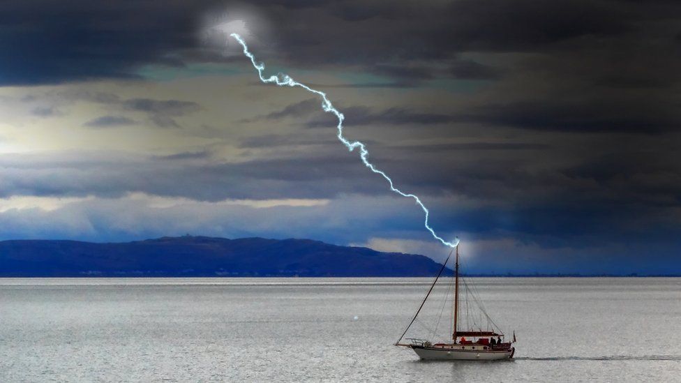 A small boat in the Bristol Channel getting struck by a bolt of lightning