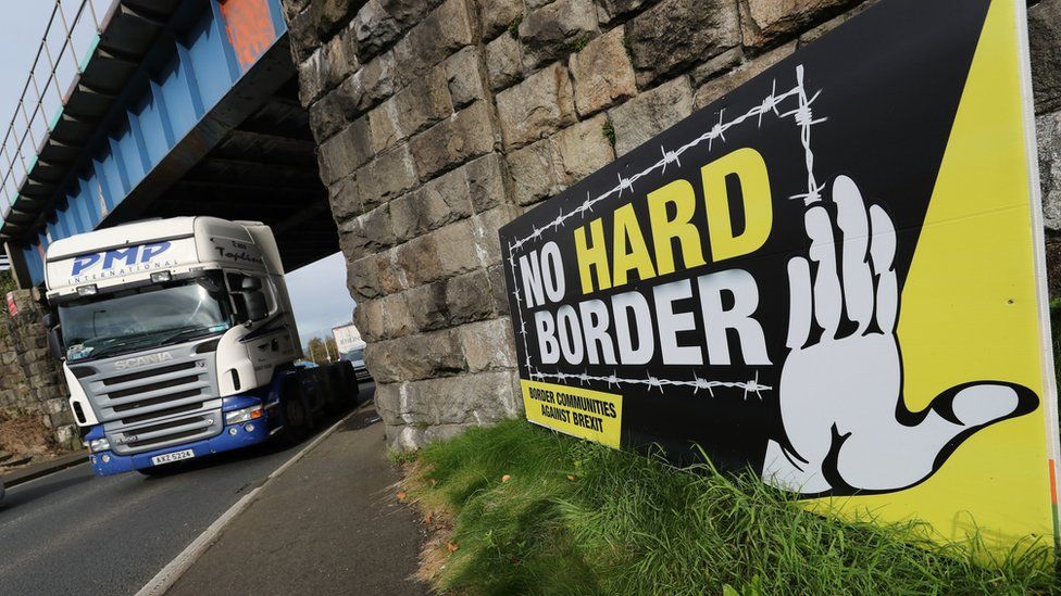 A lorry passing a sign near the Irish border that reads: no hard border