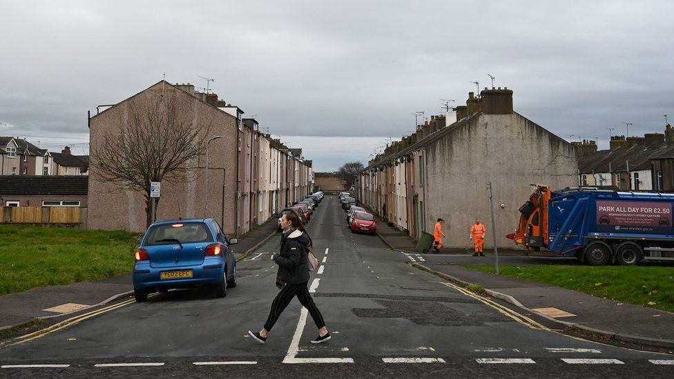 Refuse collectors work on a street in Workington, north west England on November 6, 2019