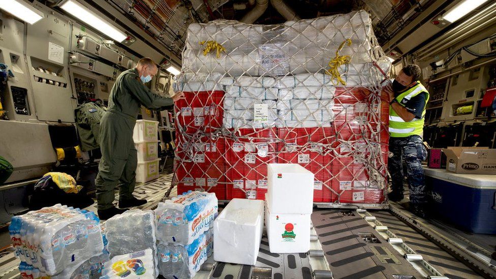An Australian Defence Force officer helps secure humanitarian aid supplies aboard a Royal Australian Air Force aircraft