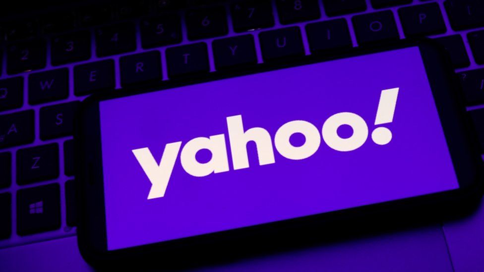 Yahoo logo on a smartphone, resting on a keyboard