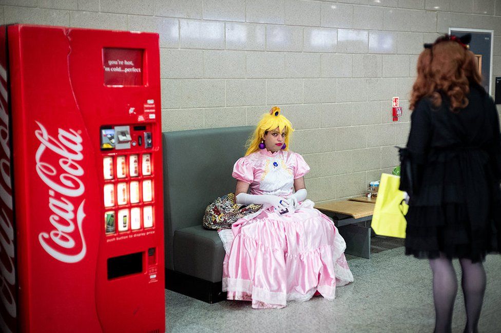 A woman dressed as a cartoon character sits and stares
