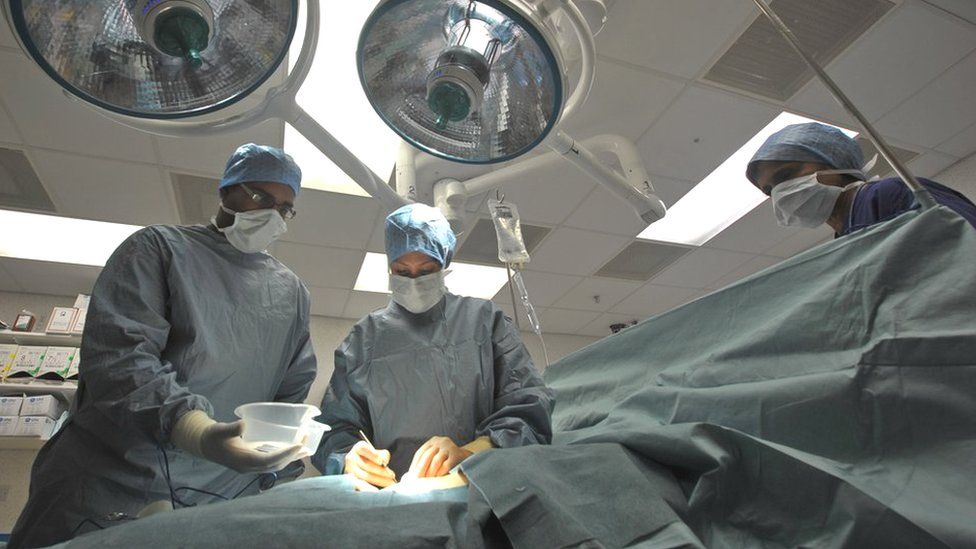 A nurse, surgeon and anaesthetist performing an operation