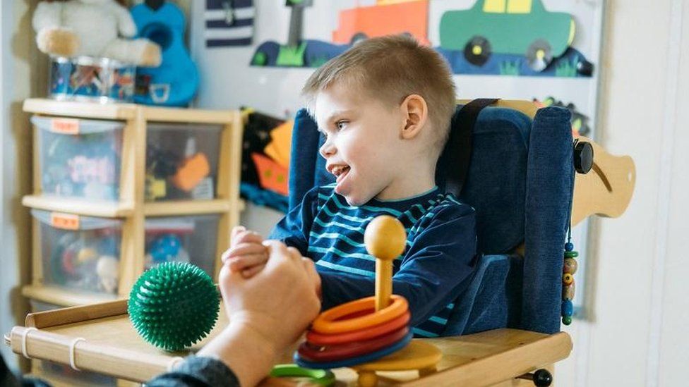 A young boy with special needs in a therapy room