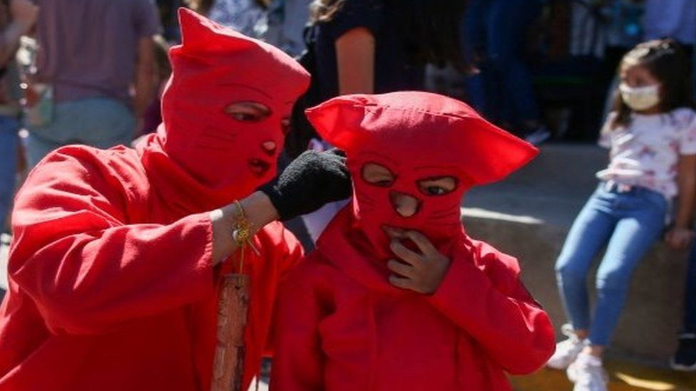Father and son dressed as demons prepare to participate in a ceremony known as Los Talciguines, as part of religious activities to mark the start of the Holy Week in Texistepeque, El Salvador, April 11, 2022.