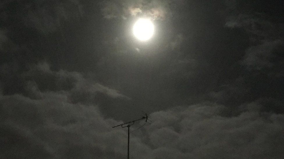 The supermoon above a rooftop