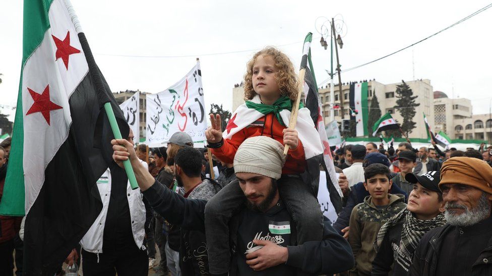 Сирийцы в удерживаемой оппозицией провинции Идлиб собрались, чтобы отметить 12-ю годовщину восстания против президента Башара Асада (15 марта 2023 г.)