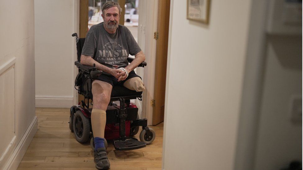 Suzanne's husband Malcolm sitting in his wheelchair