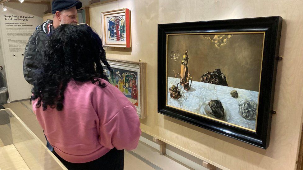 Two people look at artwork