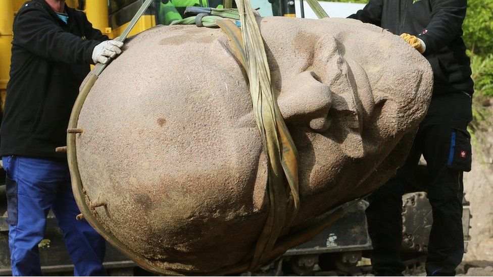 Worker remove the head of a statue of the late Soviet leader Vladimir Ilyich Lenin which was buried in a forest in the east of Berlin on 10 September 2015