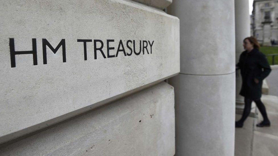 A worker enters the Treasury building in London