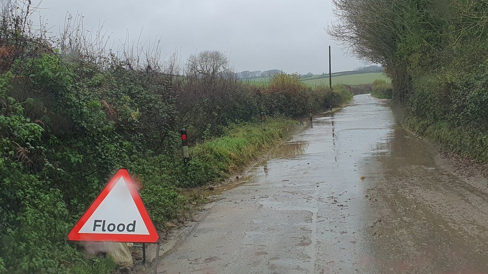 Flooded road and a flood road sign