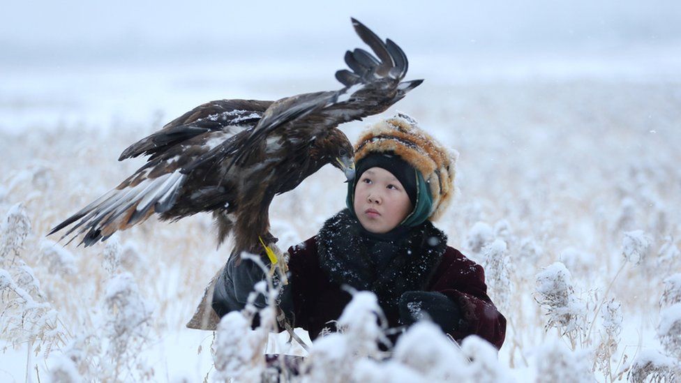 A participant holds his tamed golden eagle during a traditional hunting contest, near the town of Esik in Almaty region, Kazakhstan December 5, 2020.