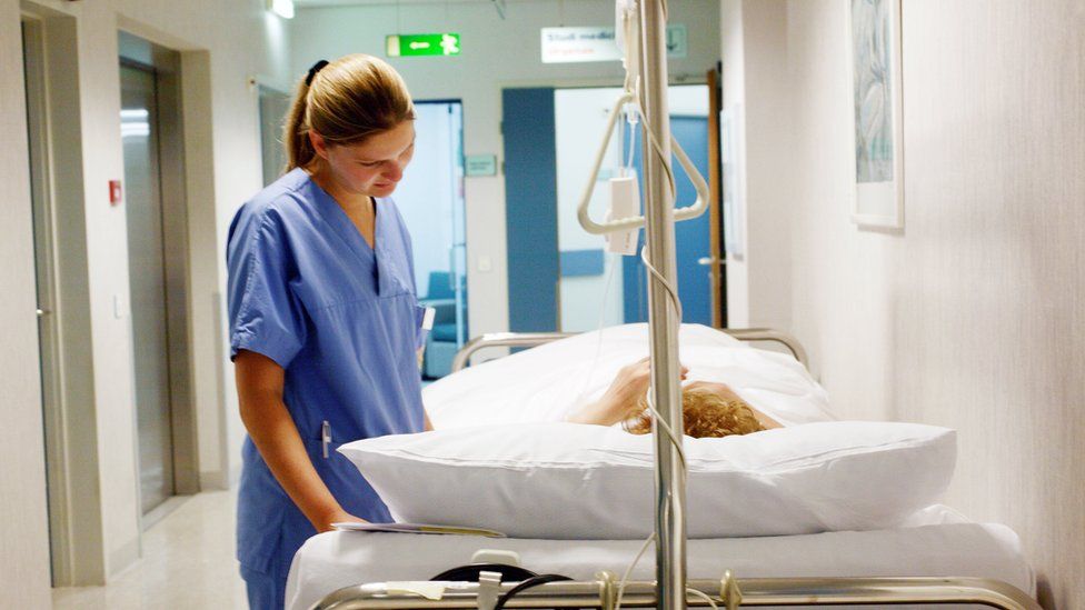 Nurse talking to a patient in a hospital bed