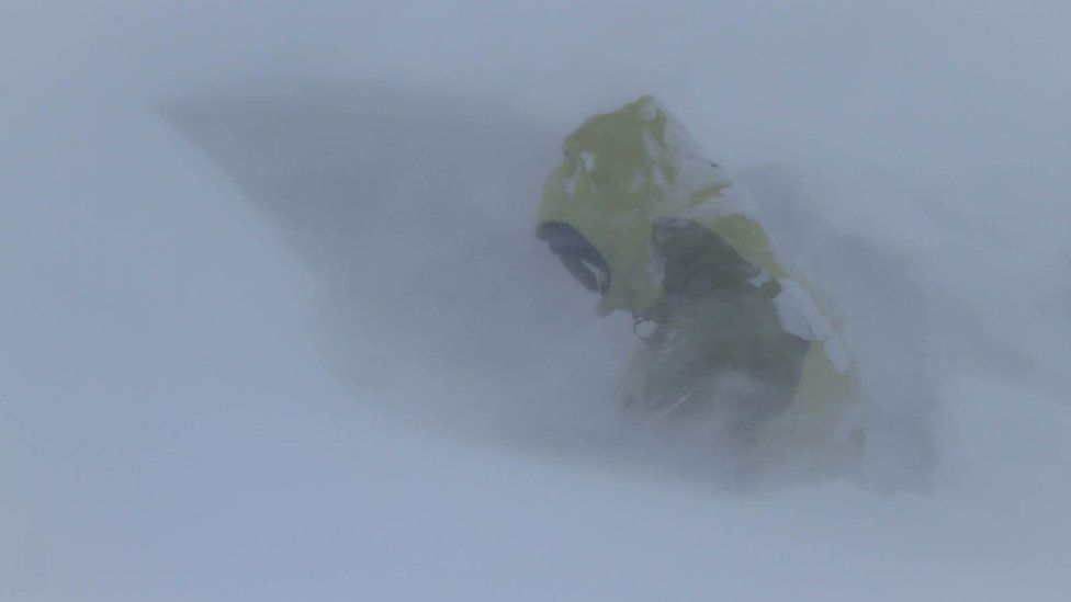 SAIS team member digging an avalanche test pit in whiteout conditions in Southern Cairngorms