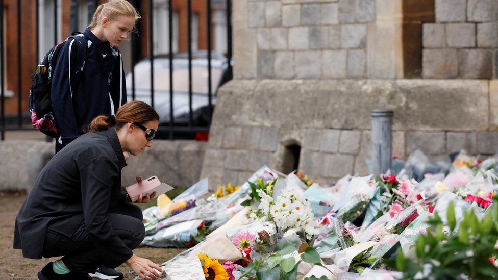 A woman and teenage girl lay flowers outside Windsor Castle