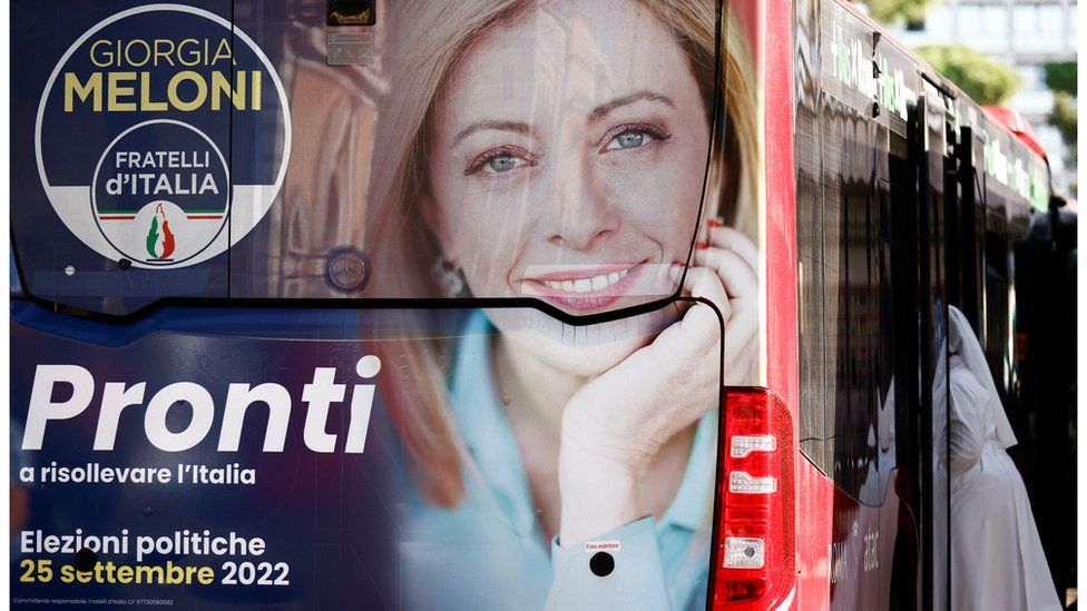 An election campaign poster of Giorgia Meloni, leader of the far-right Brothers of Italy party, is displayed on a bus ahead