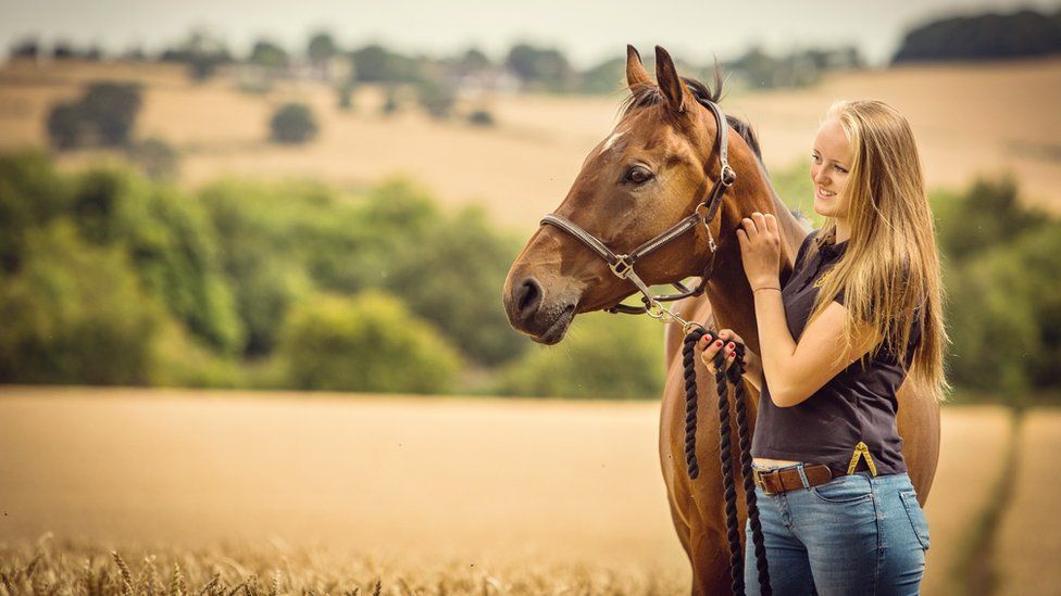 Gracie Spinks in a field with a horse