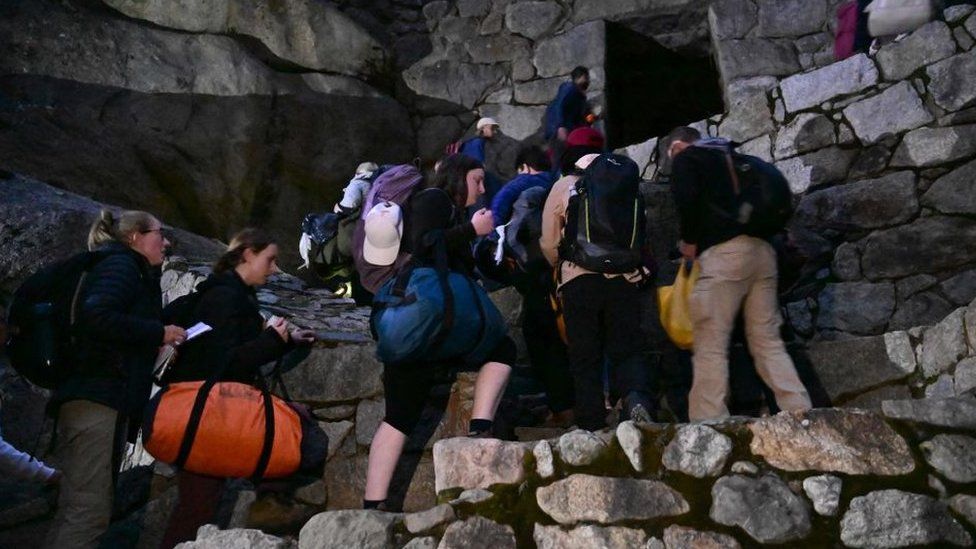 Stranded tourists who were visiting the Inca citadel of Machu Picchu trek after being evacuated by train to Ollantaytambo, Peru, on December 17, 2022.