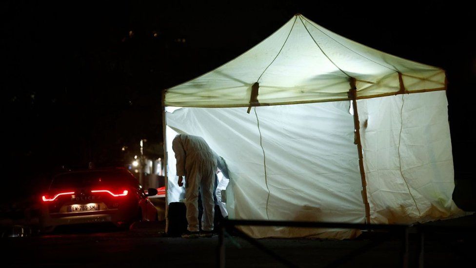 French forensic experts investigate the scene following a knife attack in Paris