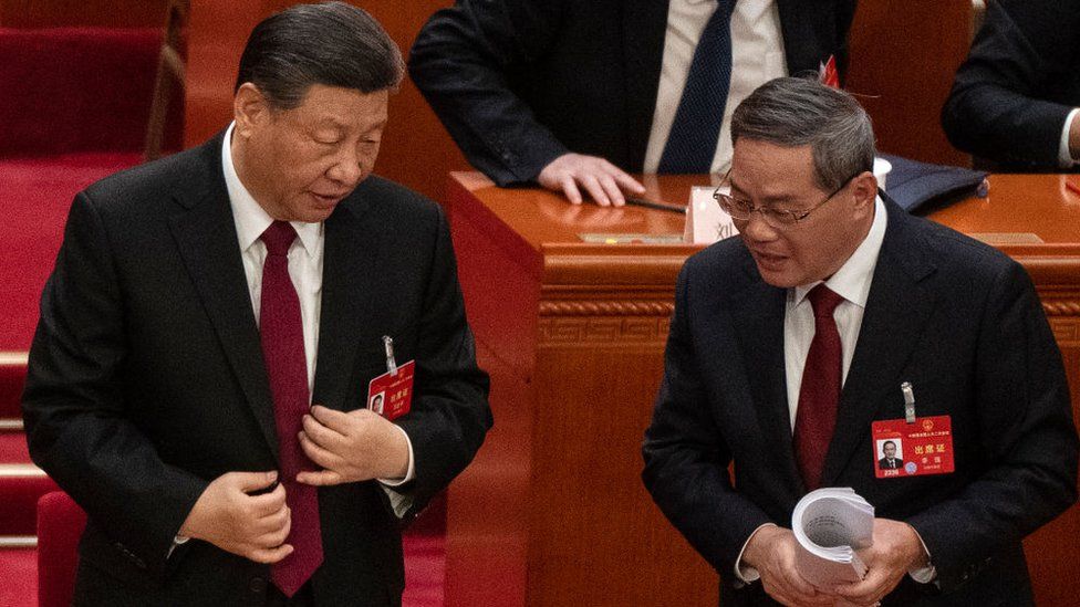 Chinese President Xi Jinping (L) speaks to Premier Li Qiang at the opening of the NPC, or National People's Congress, at the Great Hall of the People on March 5, 2024 in Beijing, China