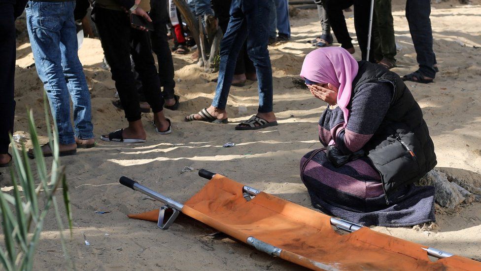 A woman reacts while Palestinians bury people killed in an Israeli strike, in the grounds of Nasser Hospital in Khan Younis, in the southern Gaza Strip (22 January 2024)