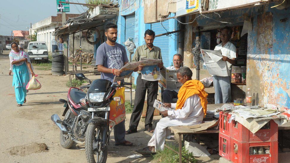 People reading newspapers in Kashmir