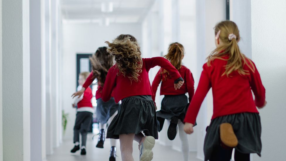 Children running down a school corridor
