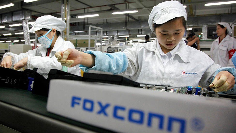 Employees work on the assembly line at Hon Hai Group's Foxconn plant in Shenzhen, China.