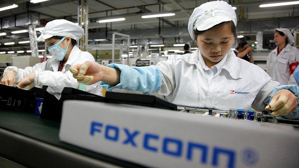 Сотрудники работают на сборочной линии на заводе Foxconn Hon Hai Group в Шэньчжэне, Китай.